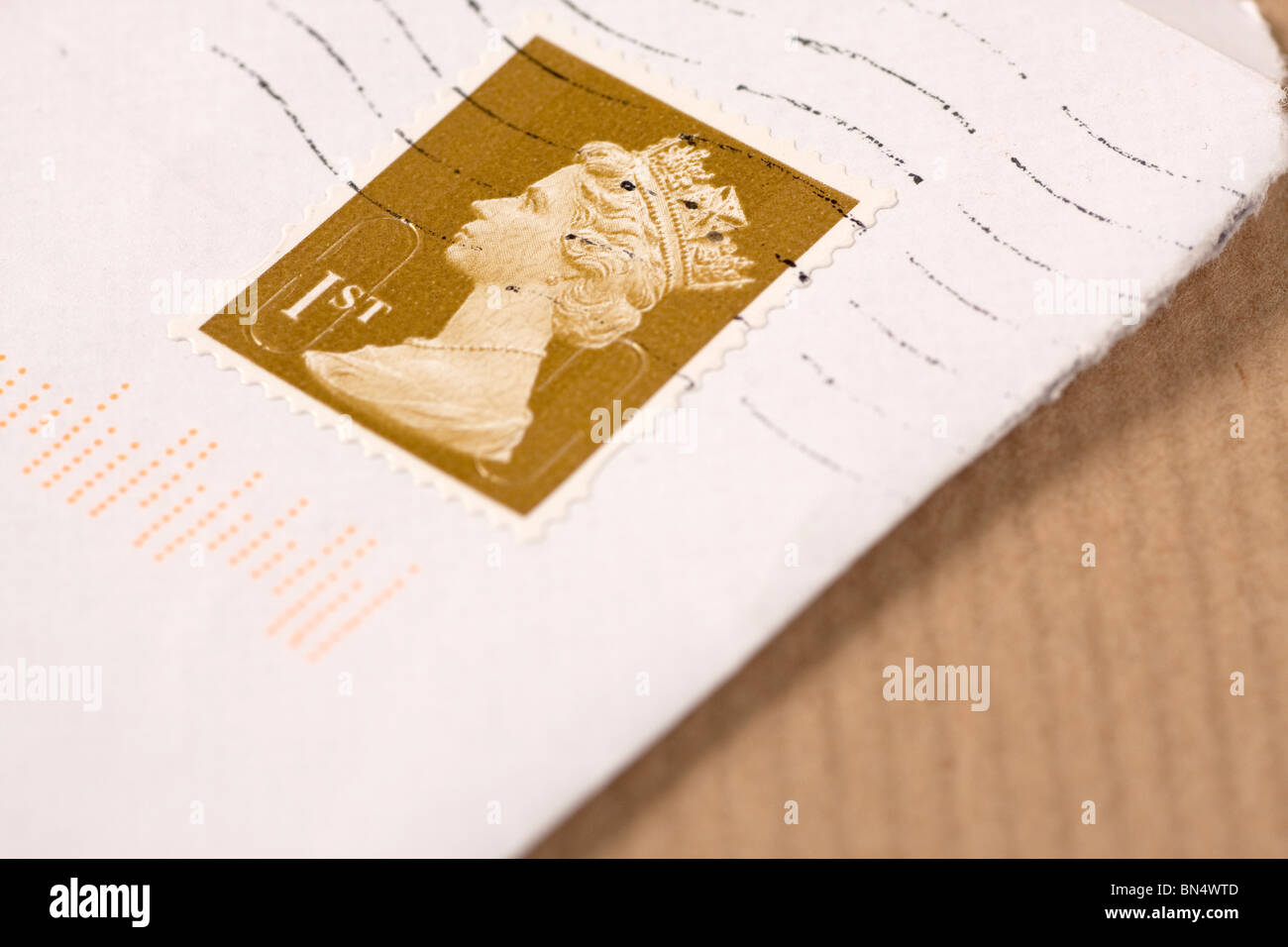 Nahaufnahme eines Umschlags mit 1. Klasse UK Briefmarke auf braunem Papier Stockfoto