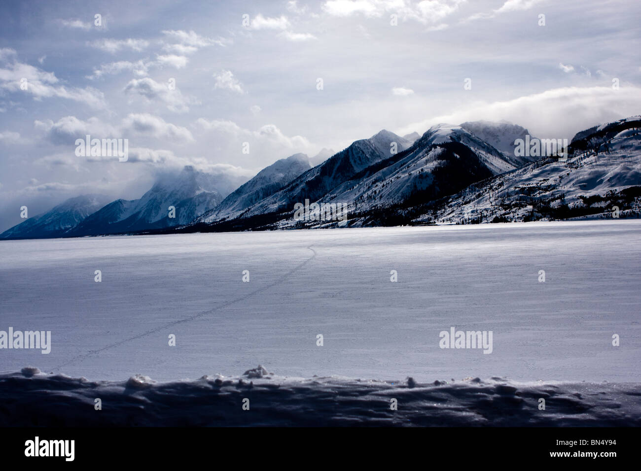 Grand Teton Bergkette im Winter hinter zugefrorenen See Stockfoto