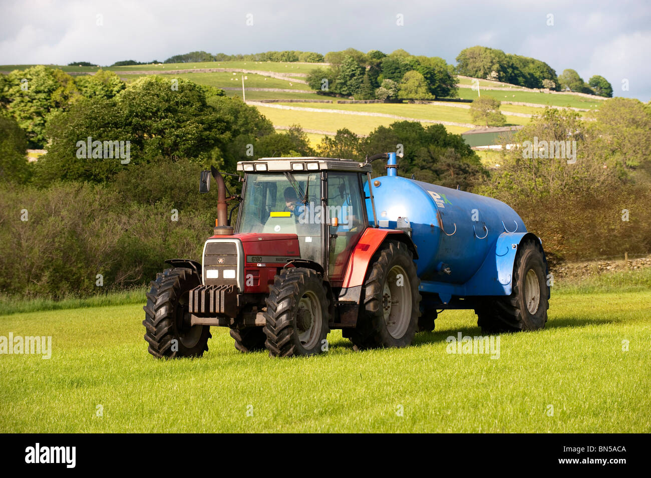 Gülle, die Verbreitung mit einem Vacum Tanker auf Rückseite ein Massey Ferguson 6180 Stockfoto