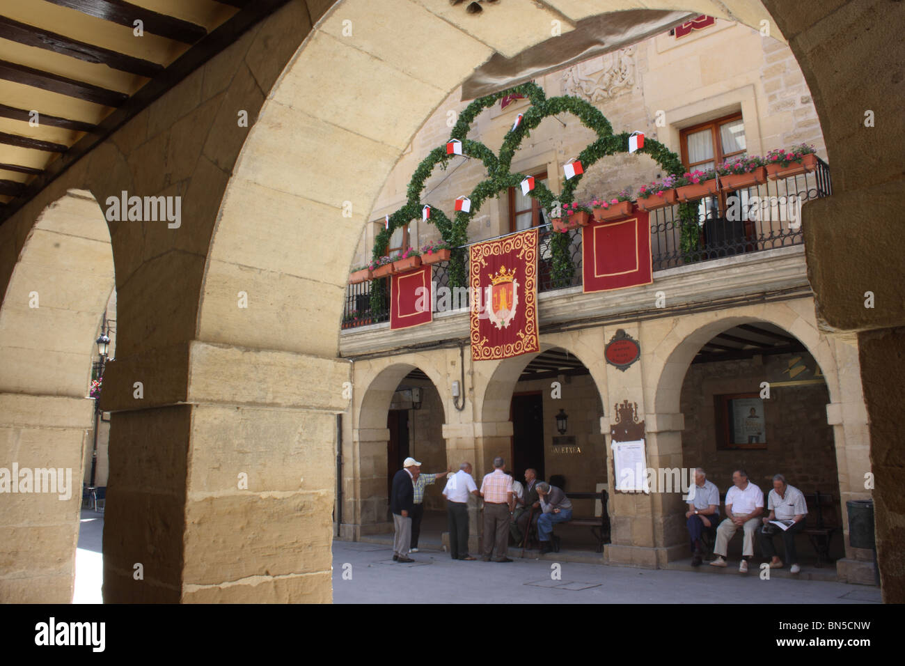 Einheimische Männer versammelten sich unter den Arkaden des Rathauses, Laguardia, Pais Vasco, Spanien Stockfoto