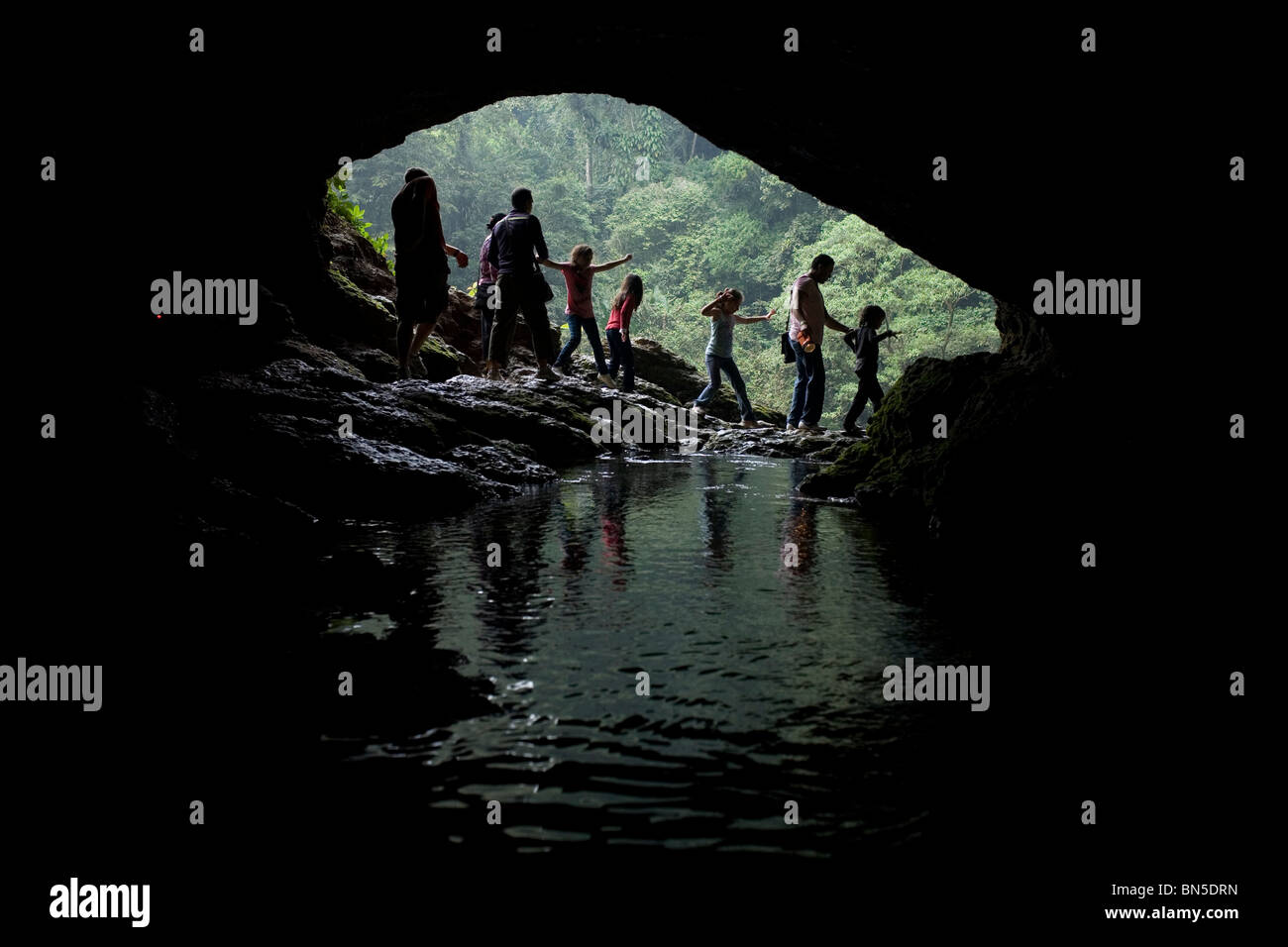 Eine Familie von Touristen besuchen eine Höhle am Wasserfall Misol Ha in Salto de Agua, Chiapas, Mexiko. Stockfoto