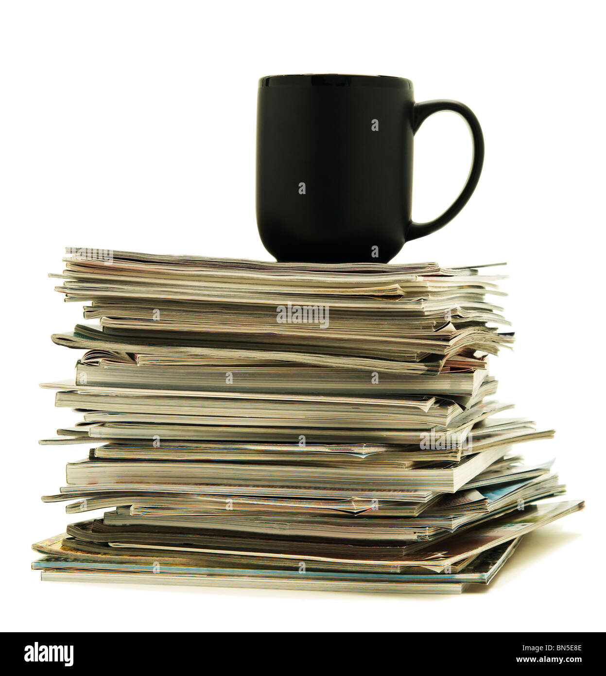 Leere Kaffeetasse sitzt auf einen Stapel Zeitschriften Stockfoto