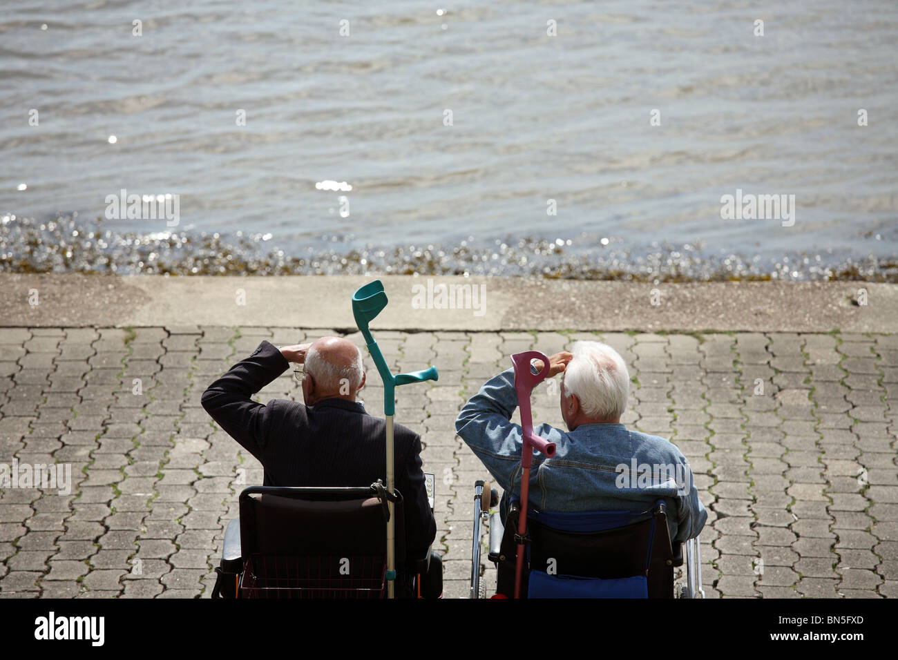 Zwei Rentner im Rollstuhl auf einen Deich, Bremerhaven, Deutschland Stockfoto