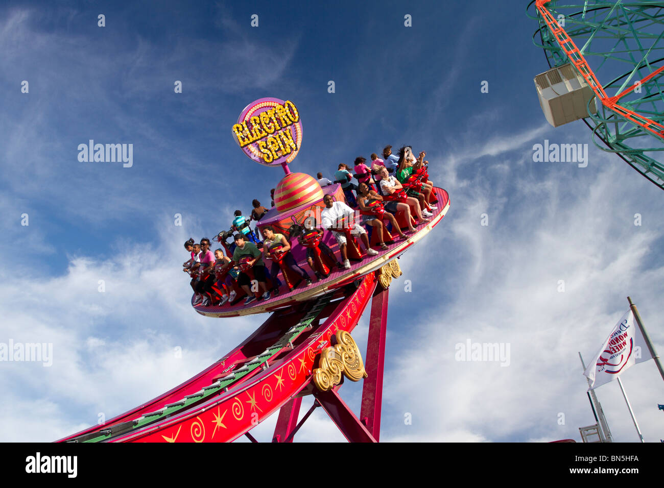 Besucher auf dem Electro-Spin fahren im neuen Luna-Park auf Coney Island, wie der Wonder Wheel im Hintergrund dreht sich Stockfoto