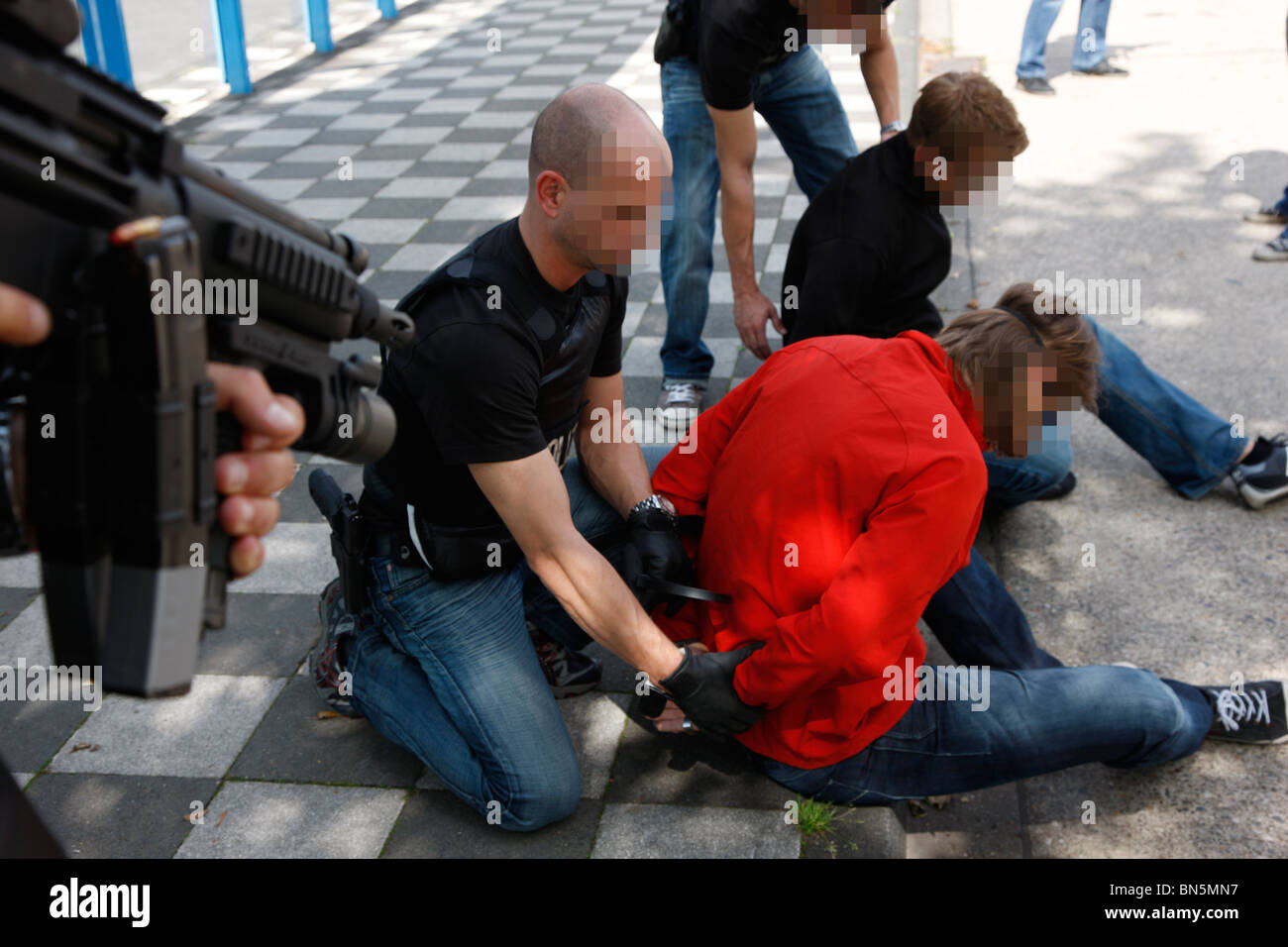 Übung der Polizei Spezialeinheiten verhaften einen Drogendealer an einer öffentlichen Bushaltestelle. Stockfoto