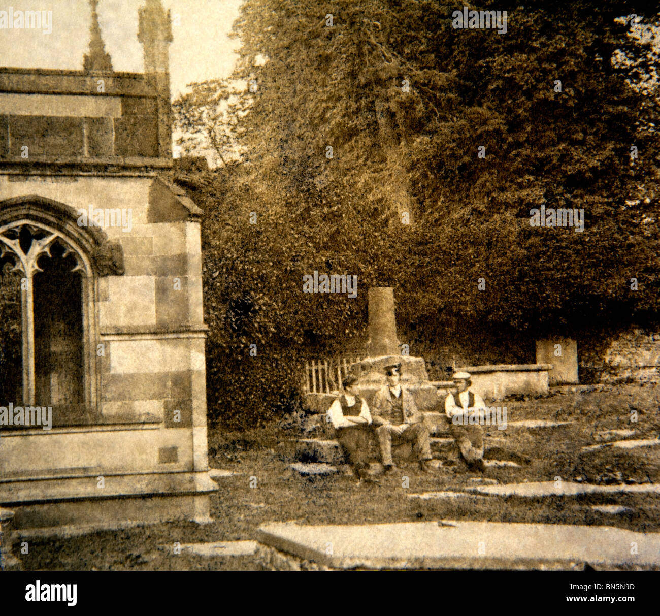 Großbritannien, England, Cheshire, Macclesfield, viktorianischen Gawsworth drei Männer sitzen auf Basis von Kirchhof in 1860er Jahren überqueren Stockfoto