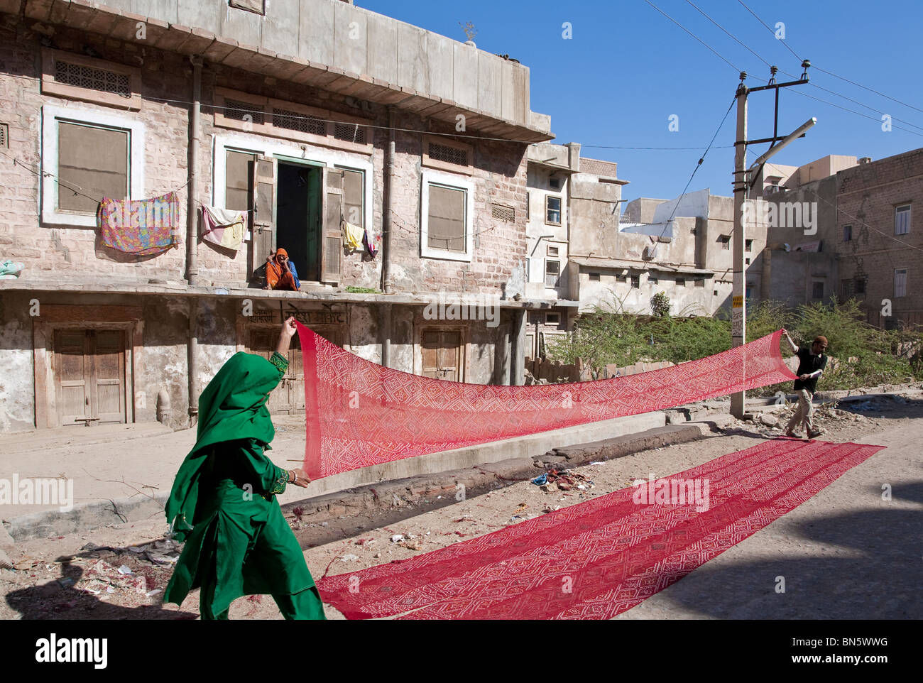 Mann und Frau Sonne trocknen rote Schals. Nagaur. Rajasthan. Indien Stockfoto