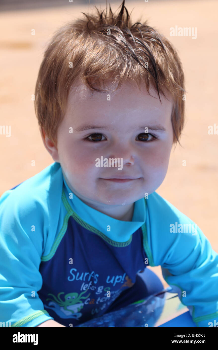 Niedlicher kleine Junge gekleidet in einem UV-Anzug im Urlaub spielen Stockfoto