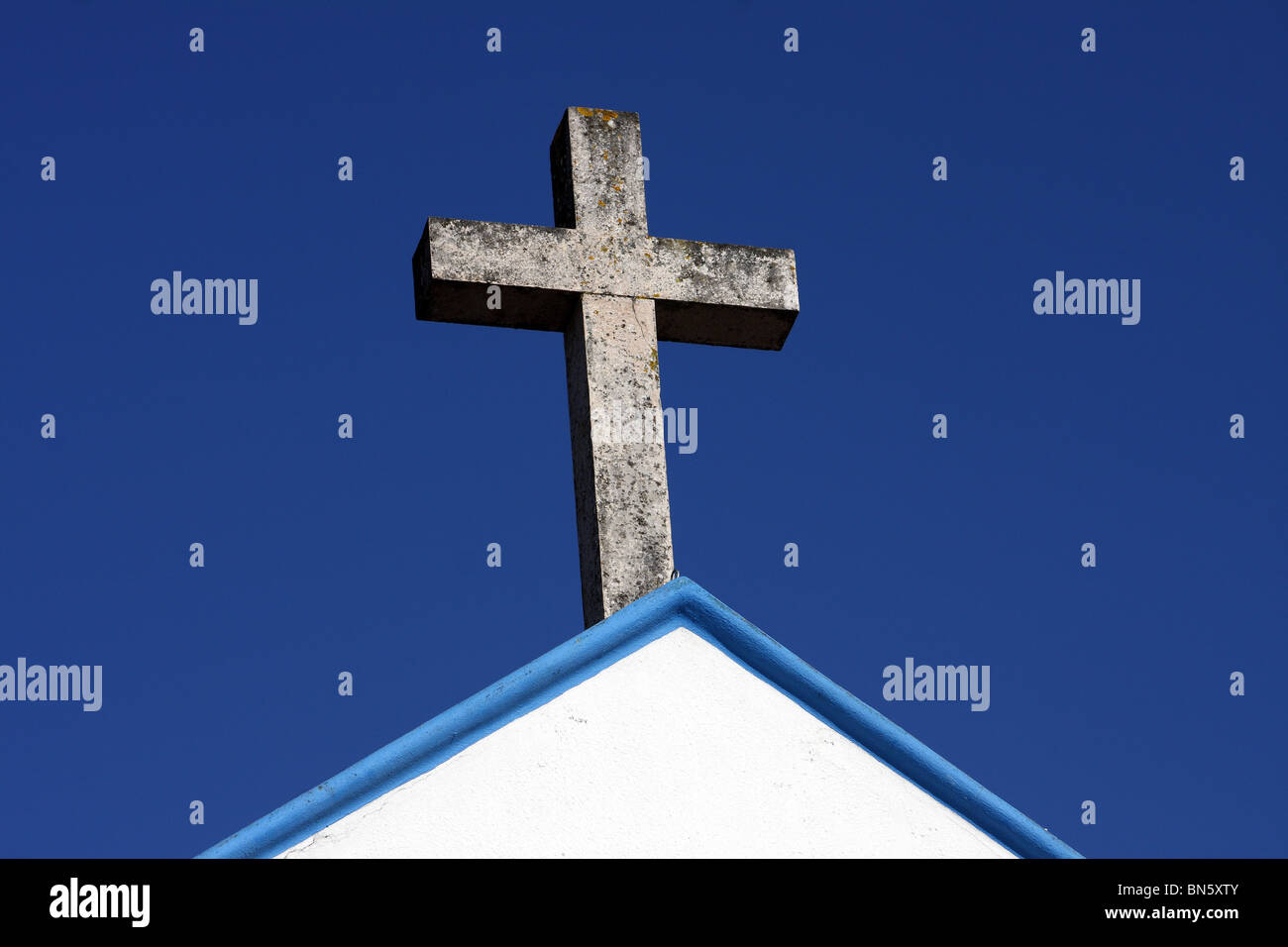 Ein Foto von einem religiösen Symbol in Form eines Kreuzes; auf der Oberseite ein Kirchengebäude in Portugal, Europa. Stockfoto