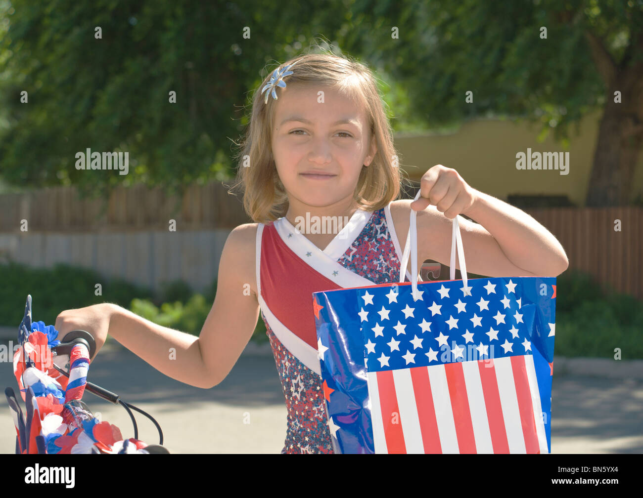 Ein patriotisches junges Mädchen zeigt stolz die amerikanische Flagge in der 4. Juli Parade, in Capitan, New Mexico. Stockfoto