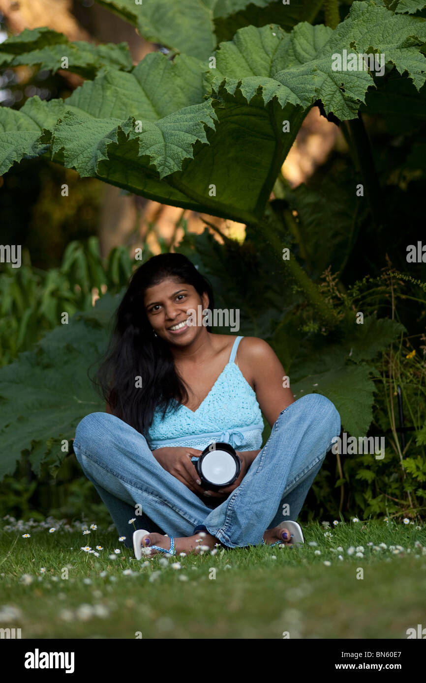 Weibliches Modell mit Kamera unter einem Baum Stockfoto