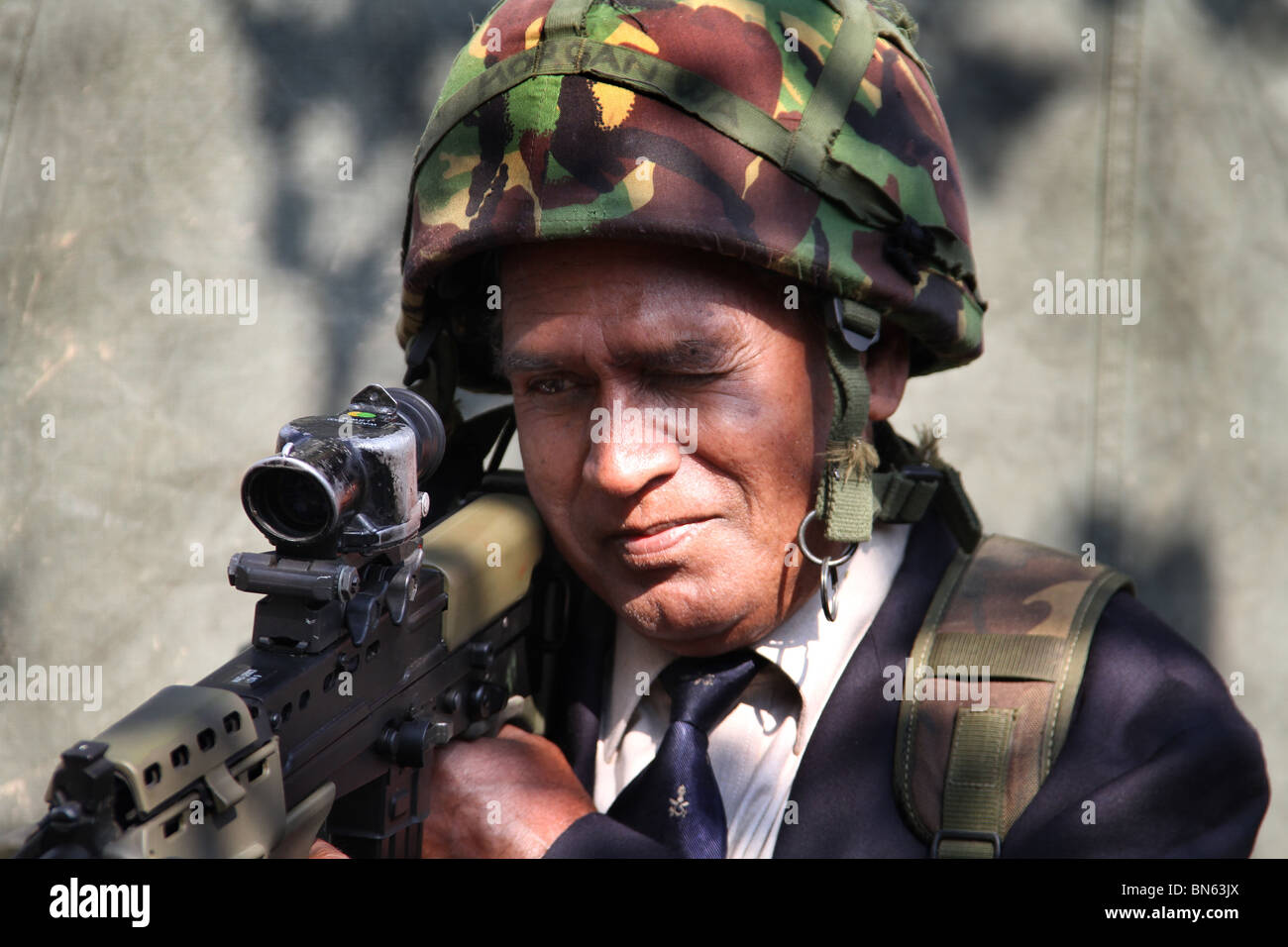 Ex-Gurka Soldat mit Helm und modernen Service-Gewehr auf Streitkräfte Tag Messe. Stockfoto