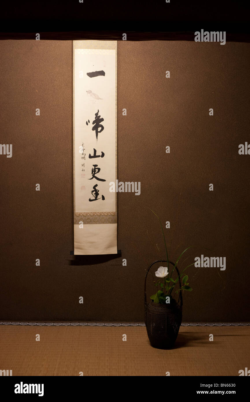 Ein hängender Schriftrolle Shodo (japanische Kalligraphie) und eine Ikebana-Gesteck schmücken die Koto-Tempel. Stockfoto
