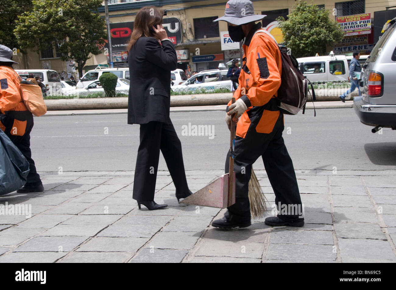 Bolivien 2010. La Paz, El Prado, Hauptstraße mit Kehrmaschine und Frau im Hosenanzug auf Handy Stockfoto