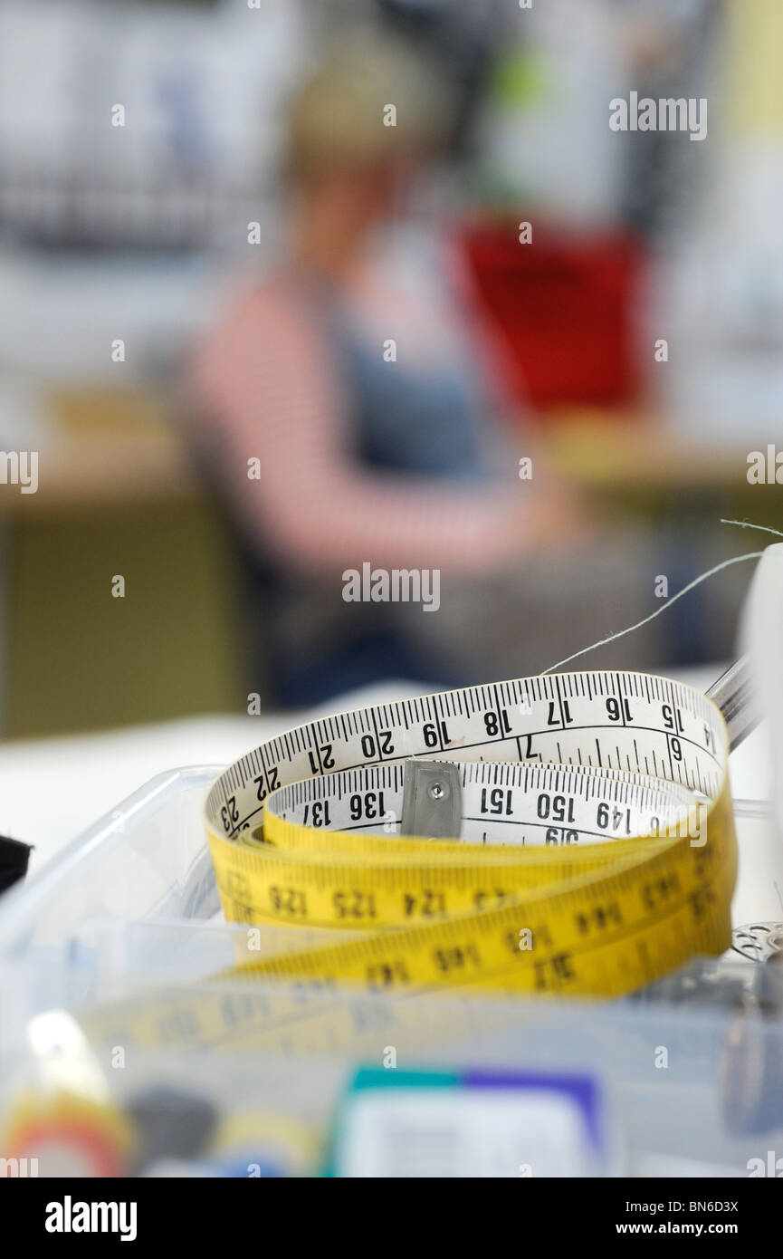 Ein Maßband auf Handarbeiten Bank zusammengerollt. Stockfoto