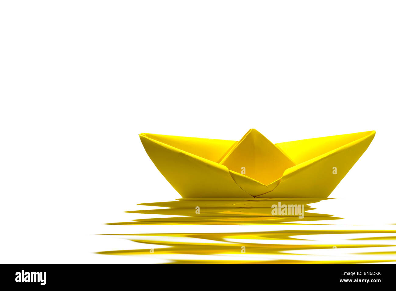 Gelbes Papierboot auf dem Wasser mit weißem Hintergrund Stockfoto