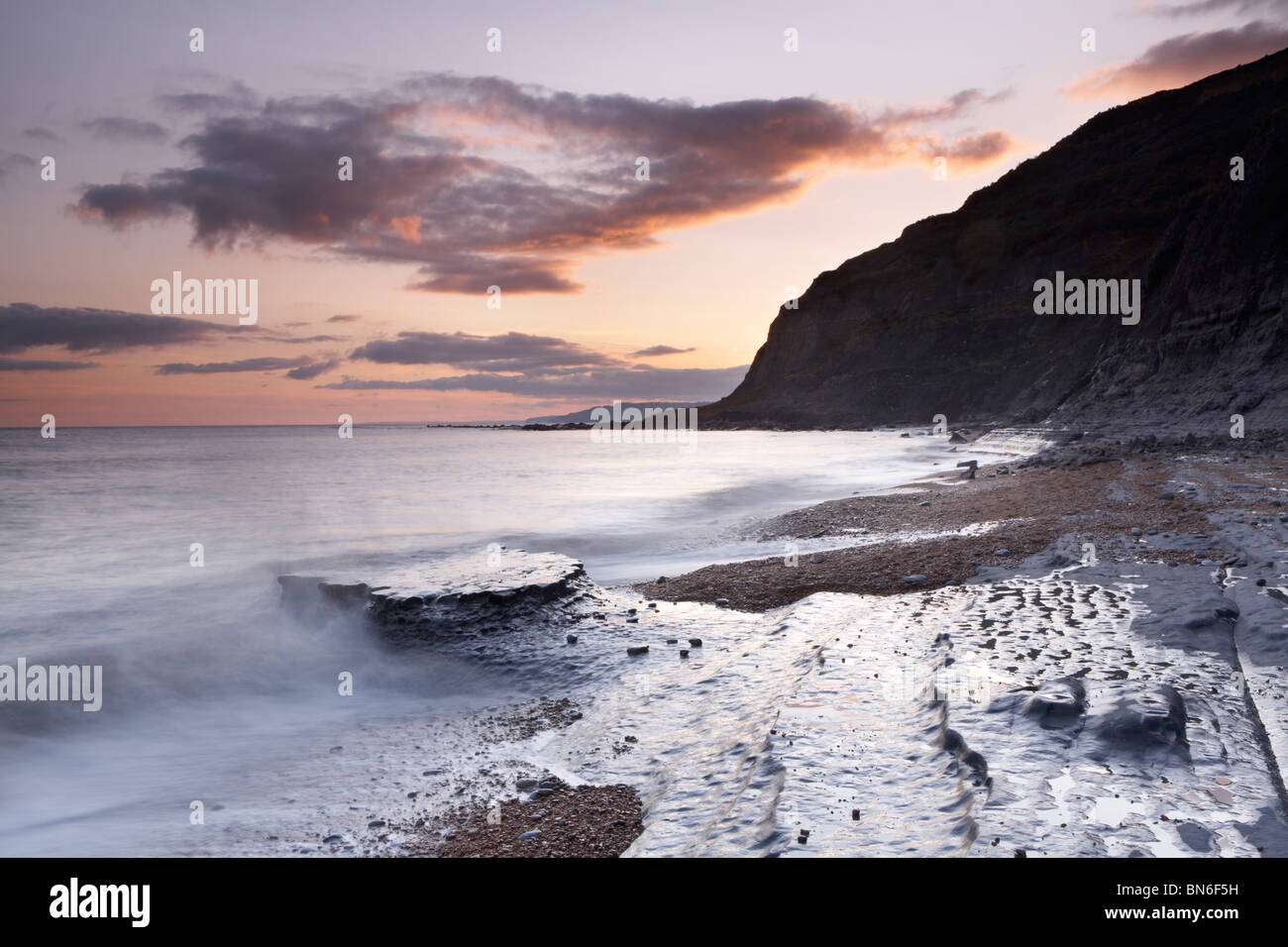 Exponierten Belemnit Stein Bett, Sonnenuntergang am einladendsten Beach in Richtung zur Unterseite des Golden Cap Cliff, Dorset Küste, England, UK Stockfoto