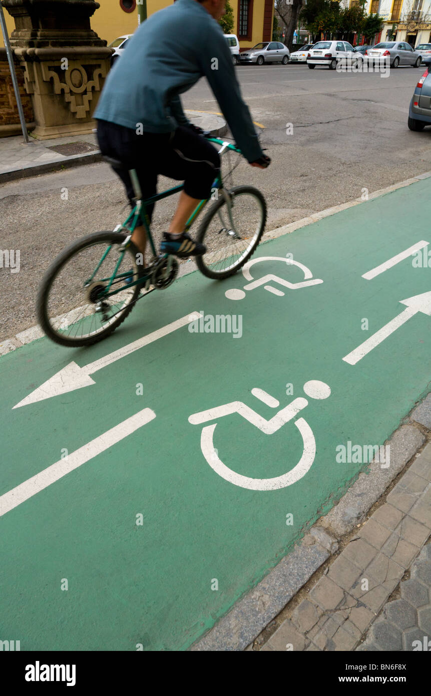 Radfahrer-Zyklen auf einen spanischen Rollstuhl / Behinderte Person und Fahrrad / bike / Fahrrad / Bahnen / Lane in Sevilla, Spanien. Stockfoto