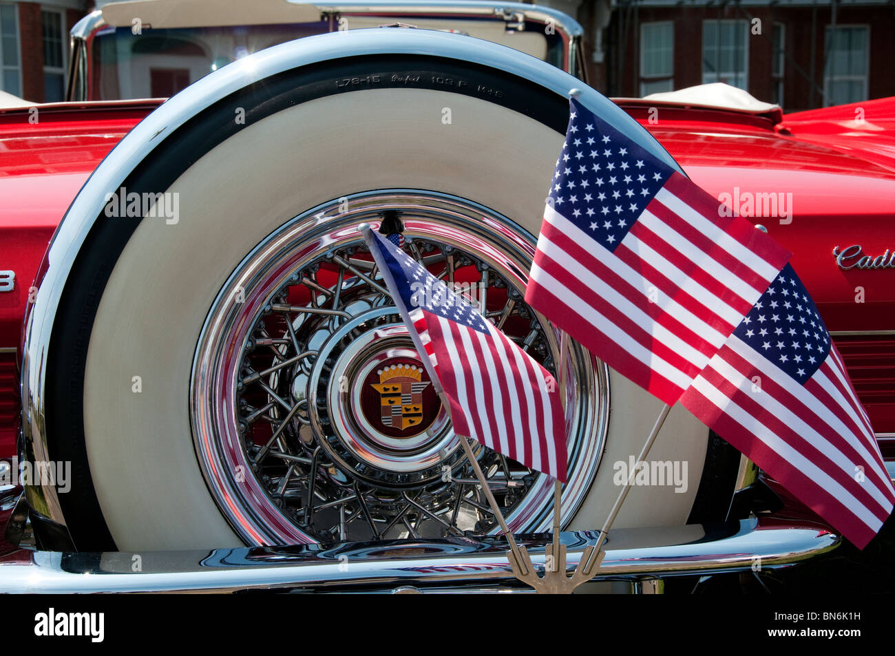 Ersatzrad und amerikanische Flaggen auf der Rückseite von einem klassischen roten Cadillac Cabrio Stockfoto