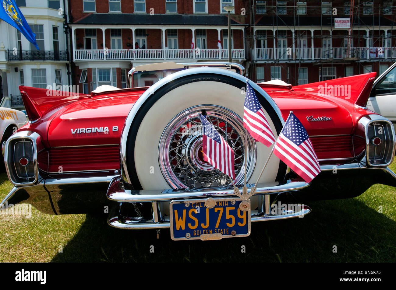 Ersatzrad und amerikanische Flaggen auf der Rückseite von einem klassischen roten Cadillac Cabrio Stockfoto