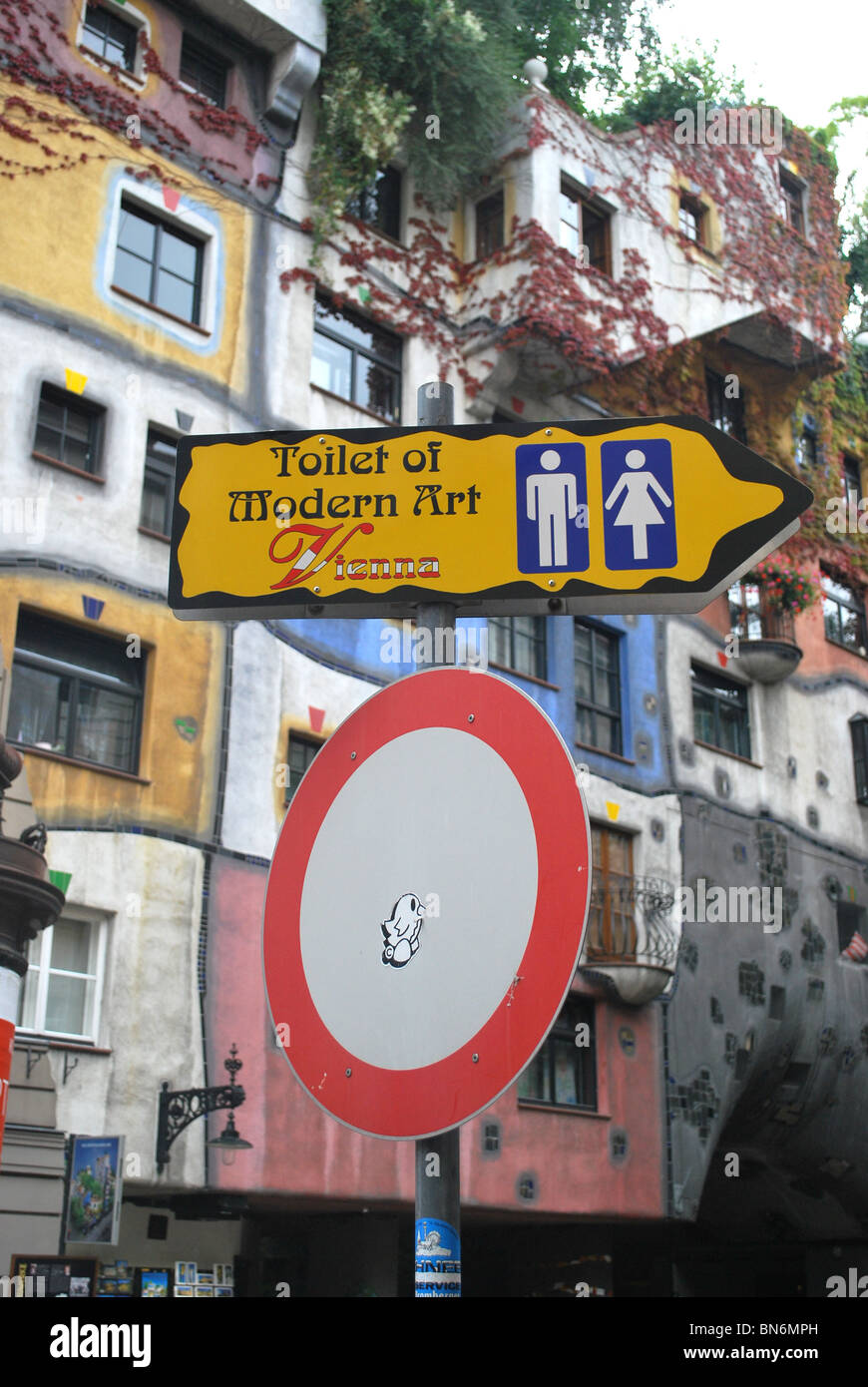 "Toilette der modernen Kunst" Schild mit Hundertwasser-Haus im Hintergrund Stockfoto