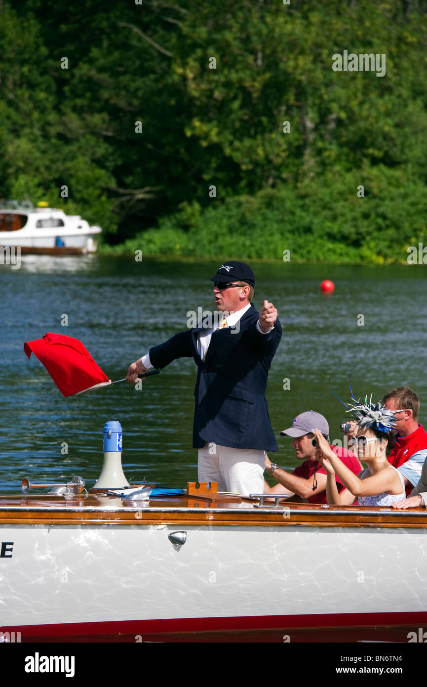 Ein Schiedsrichter Anweisungen geben und schwenkte eine rote Fahne in einem Themse Start beginnt ein Rennen auf der Henley Royal Regatta Stockfoto