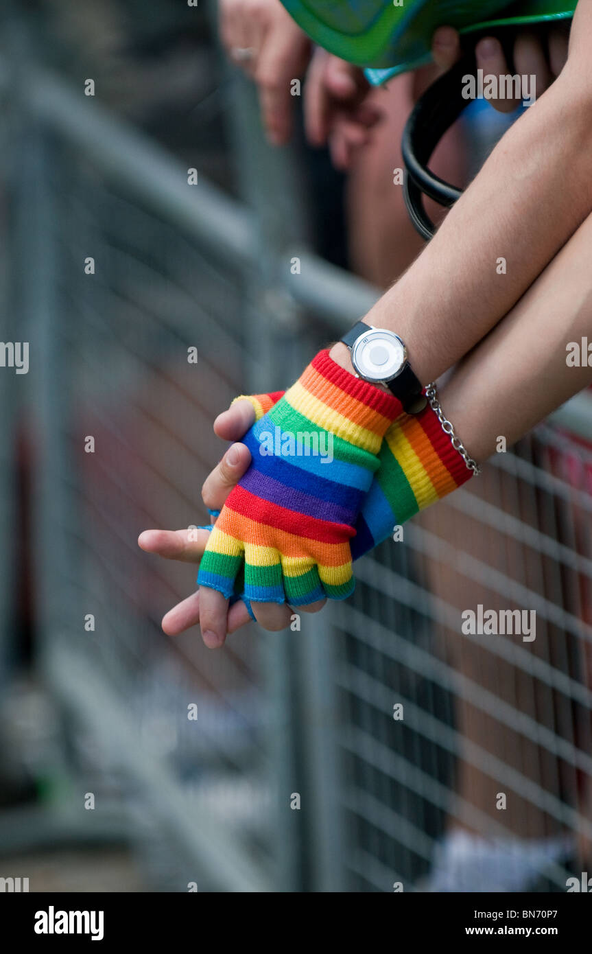 Bunte fingerlose Handschuhe getragen von zwei schwule bei den London Pride Feierlichkeiten in London. Stockfoto