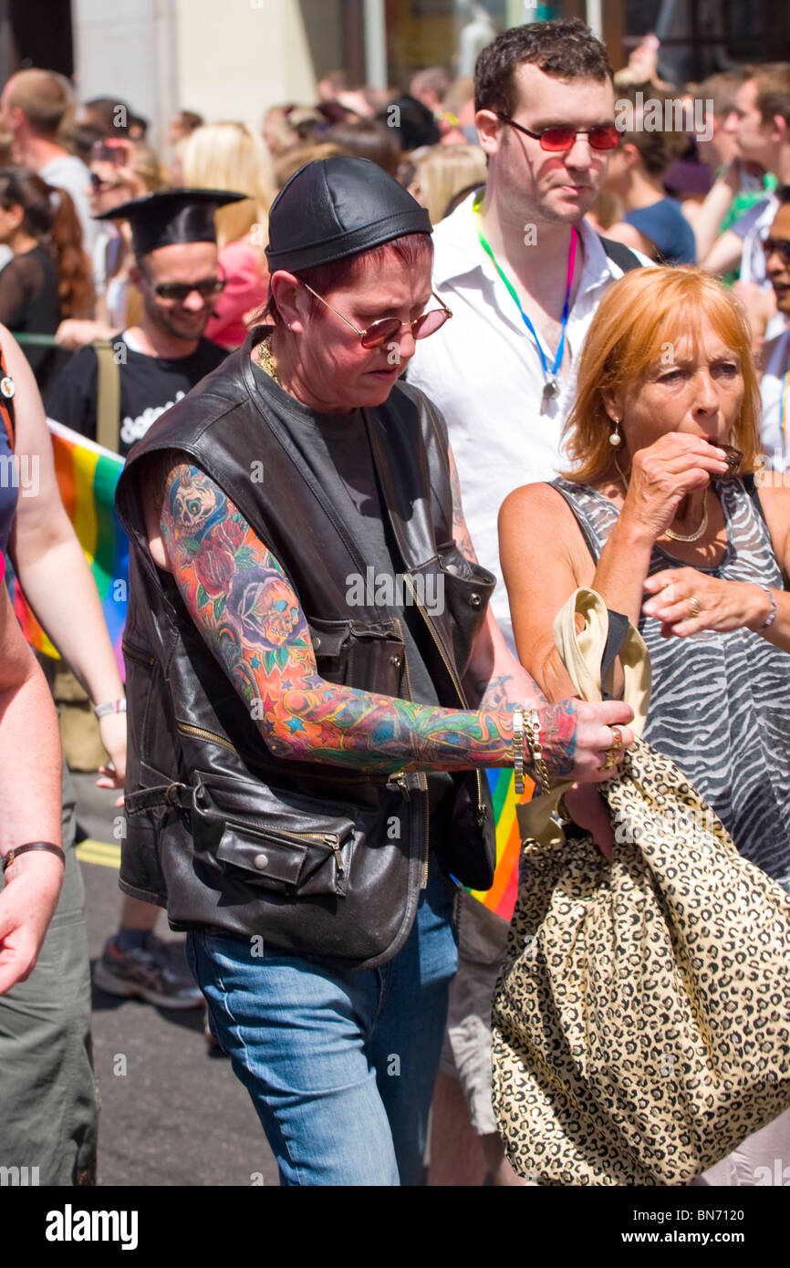 London-Gay-Pride-Parade, Mann mit farbigen Tattoo auf Arm, gold-Armbänder,  Ringe & Halsketten & schwarzes Leder Weste & Hut Stockfotografie - Alamy
