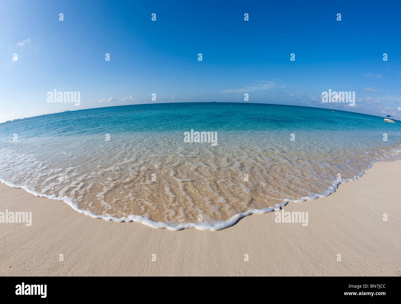 Sanfte Wellen schwappen ans Ufer am Seven Mile Beach in Grand Cayman Stockfoto