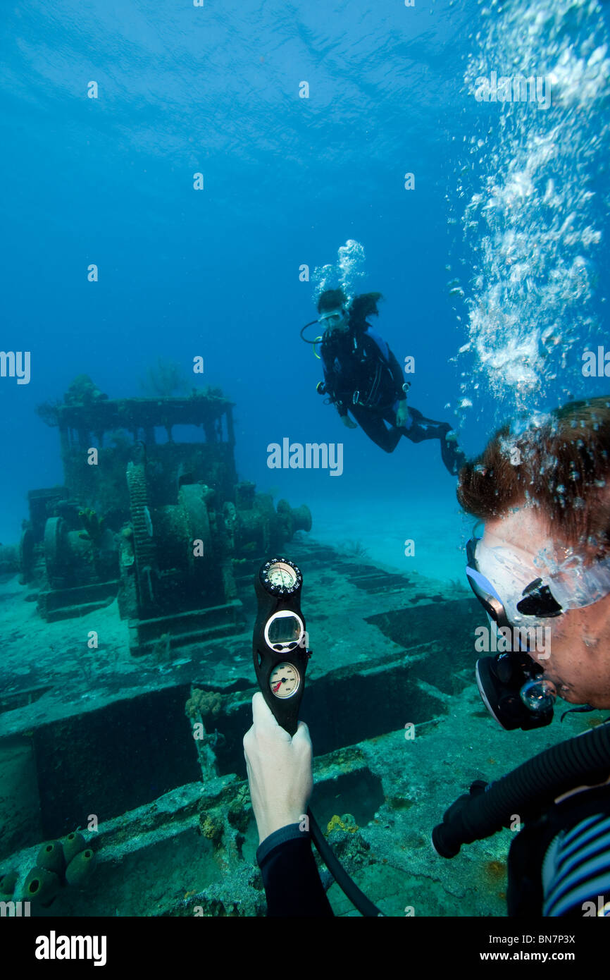 Taucher prüft verbleibenden Luftzufuhr und Tiefe über seine Scuba-Konsole beim Tauchen in Grand Cayman Stockfoto