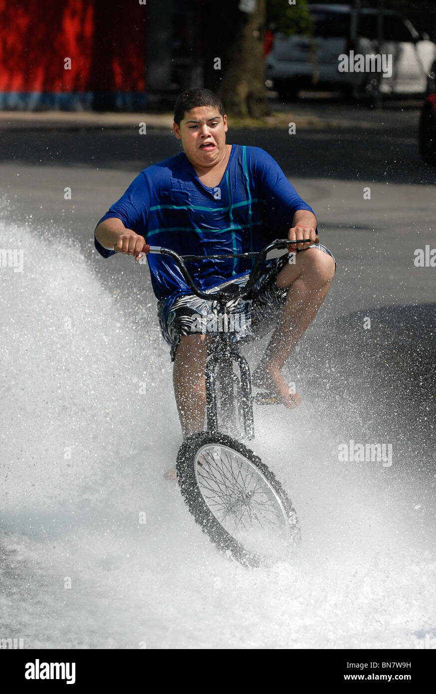 Eine Teenager hat einen Blick des Grauens auf seinem Gesicht, als sein Vorderrad vom Fahrrad fällt, dabei einen Wheelie. Die Teen blieb unverletzt. Stockfoto