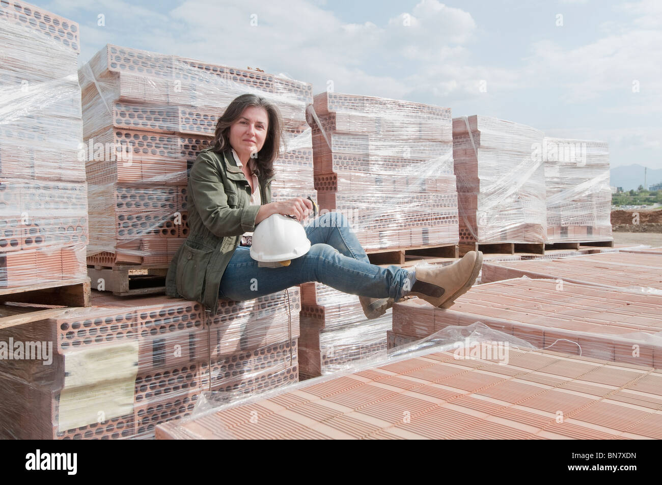 Kaukasische Bauarbeiter sitzen auf Stapel von bricks Stockfoto