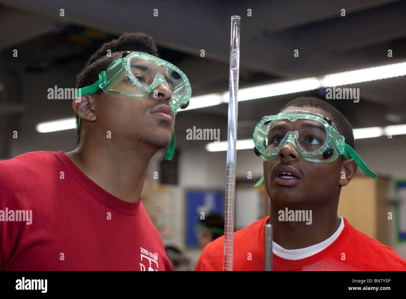 Schutzbrille tragen männliche Gymnasiasten führen eine Titration-Experiment  mit Messzylinder im Chemieunterricht Stockfotografie - Alamy