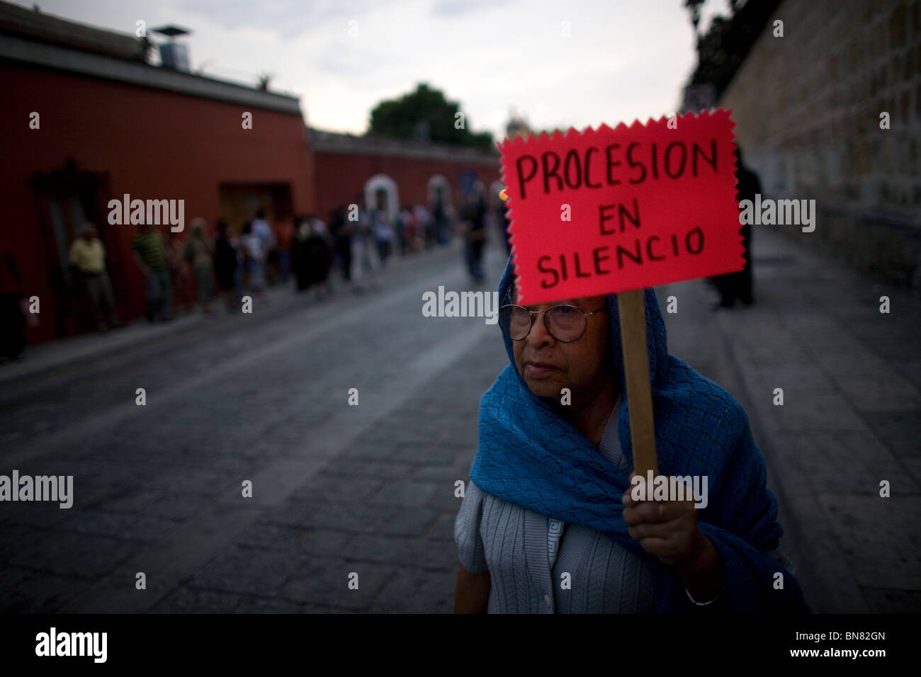 Eine ältere Frau zeigt ein Zeichen, das "Prozession in der Stille" liest während der Karwoche feiern in Oaxaca, Mexiko. Stockfoto