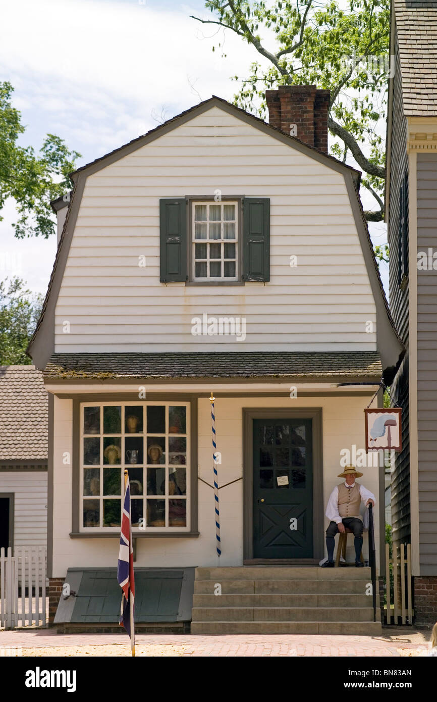 Kostümierter Kaufmann wartet draußen für die Besucher seine Perückenmachers Shop auf Duke of Gloucester Street im historischen Colonial Williamsburg in Virginia, USA. Stockfoto