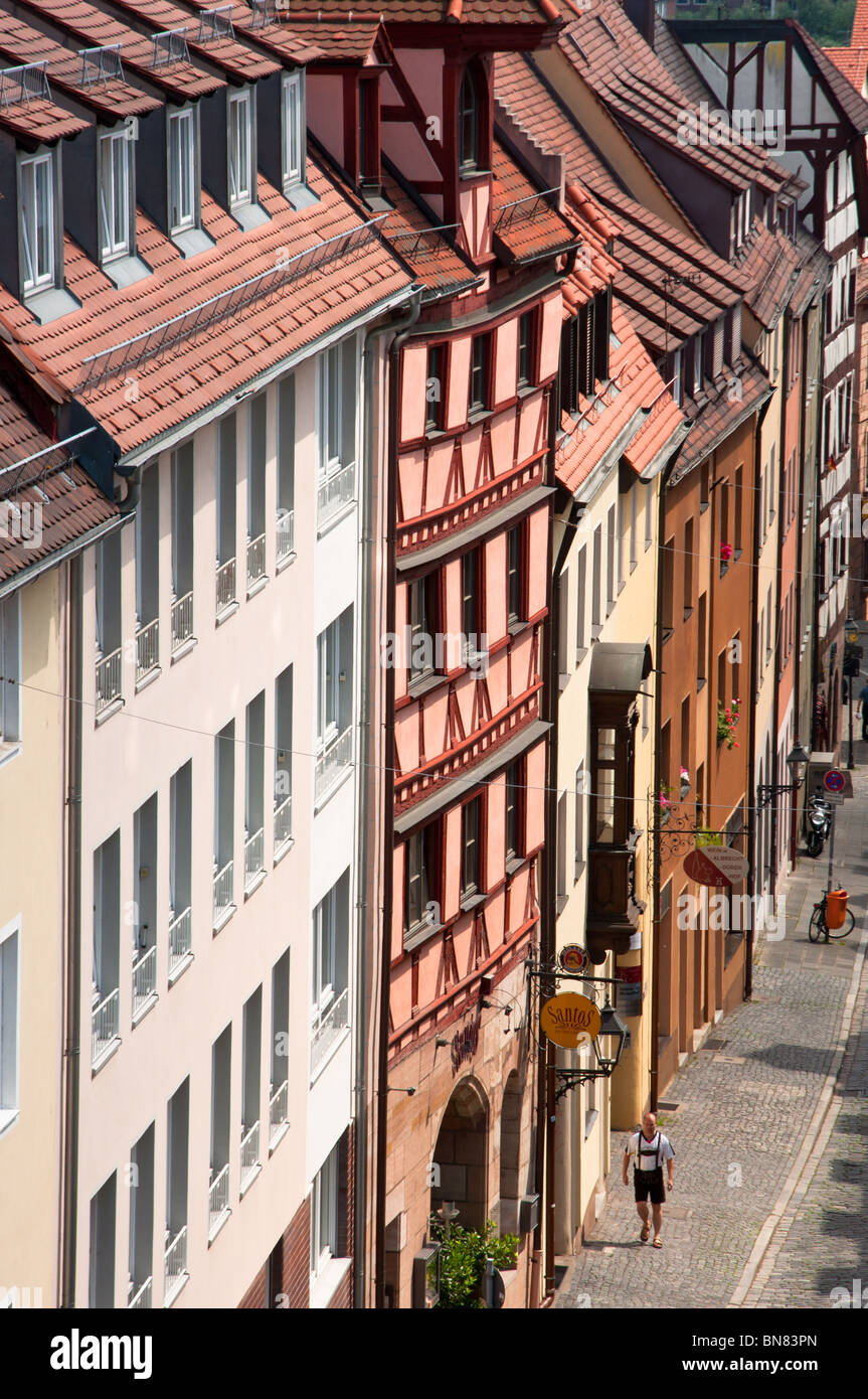 Nürnberg traditionelle Holz gestaltete Fassade mit einem Mann in bayerischer Tracht auf der Straße. Stockfoto