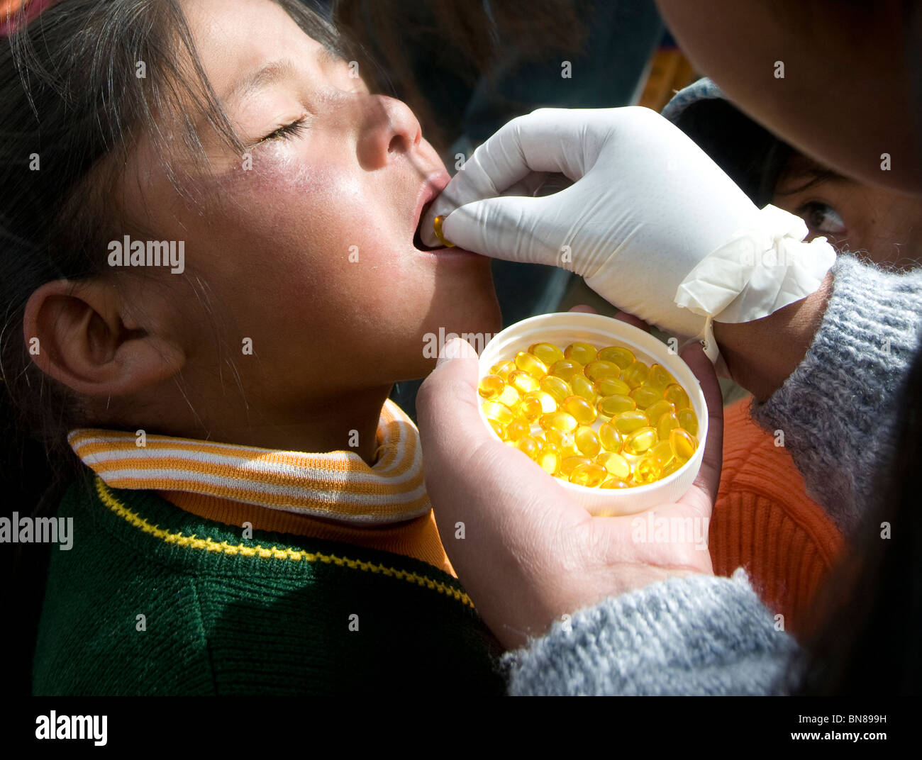 El Alto.Primary Schulkind ist bestimmten Lebertran / Vitamin A-Tablette Stockfoto