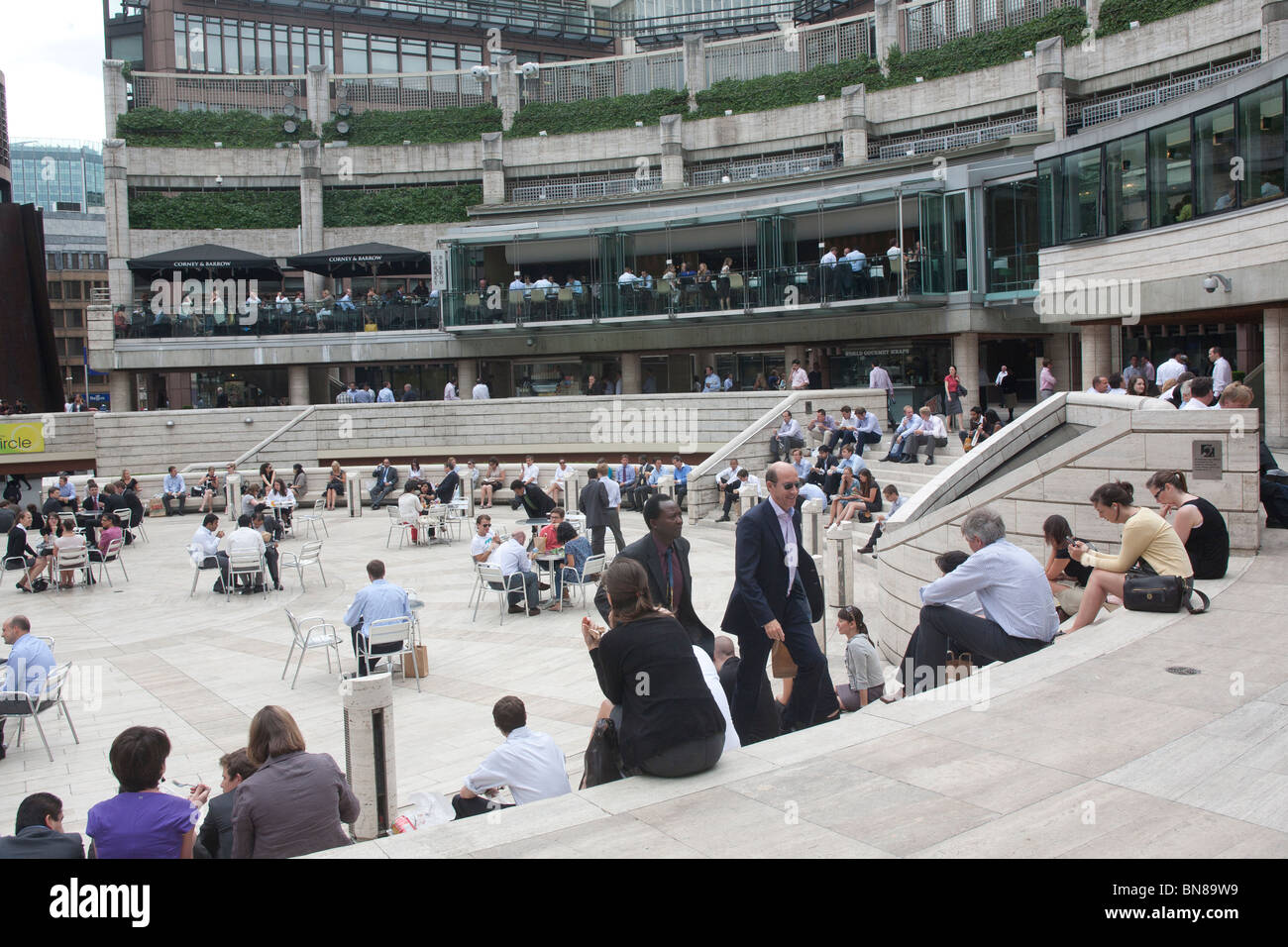 Stadtarbeiter entspannen während der Mittagspause in Broadgate Centre, City of London GB Großbritannien Stockfoto