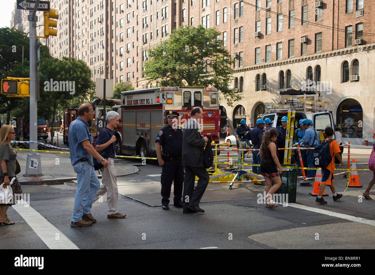 Passanten und Ersthelfer am Unfallort ein Schacht Feuer auf West 23rd Street in dem trendigen Chelsea-Viertel von New York Stockfoto