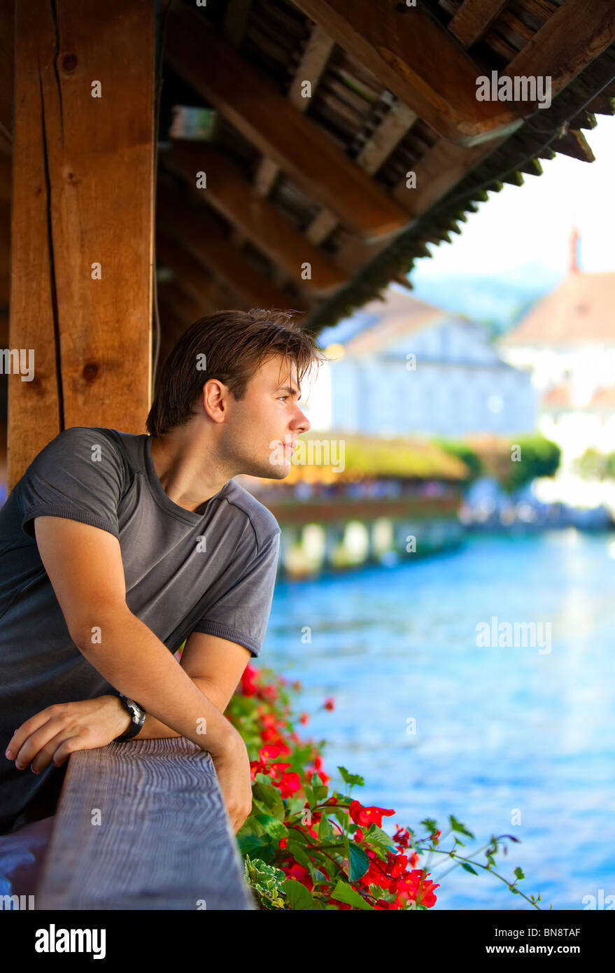 Junger Mann auf einer Brücke, auf der Suche zur Seite Porträt. Stockfoto