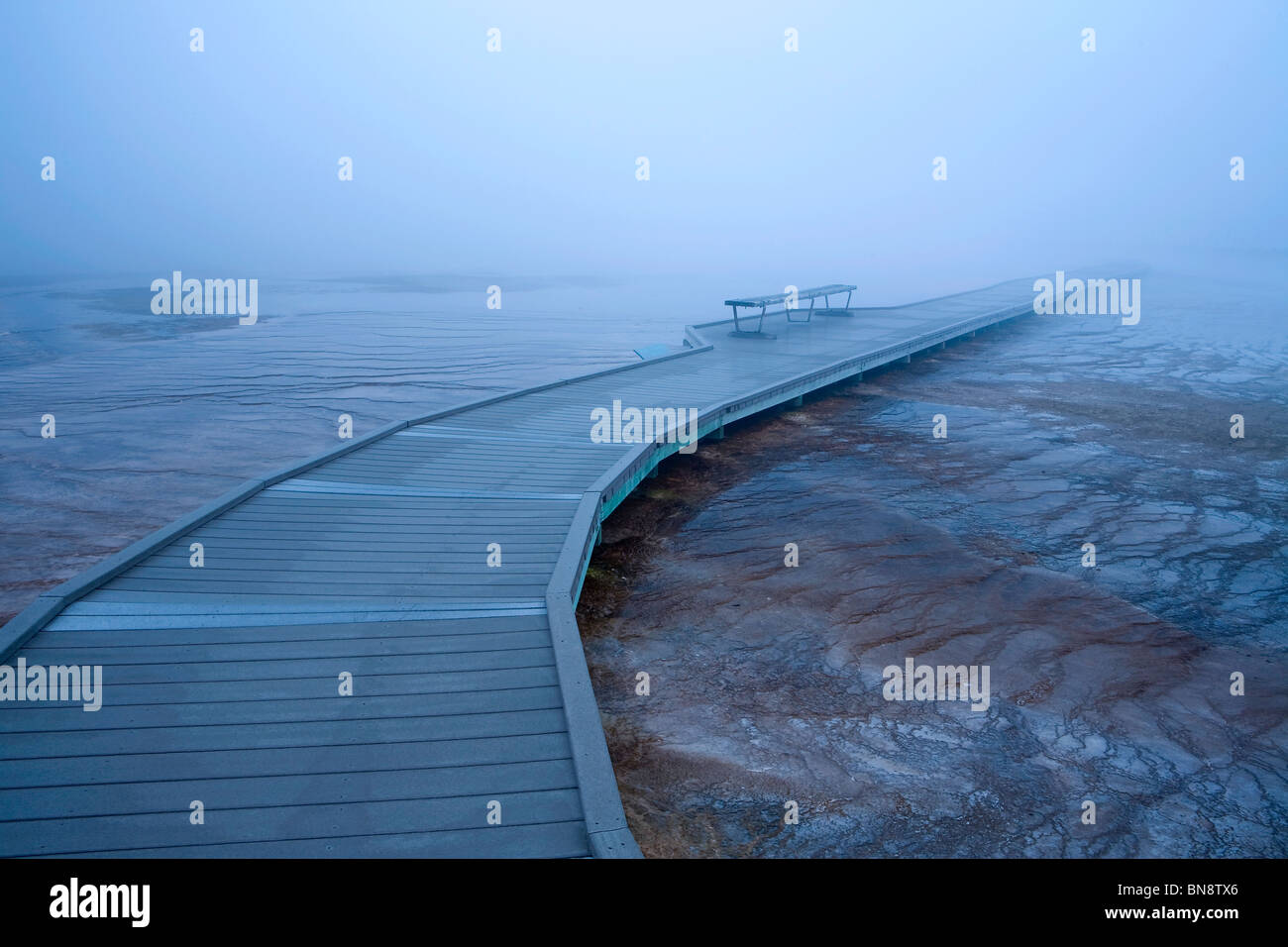 Boardwalk und Bank im Morgennebel um Grand Bildobjekte Spring im Yellowstone-Nationalpark, Wyoming, USA Stockfoto