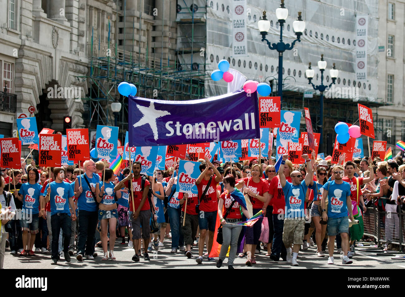 Teilnehmer Plakate und eine Stonewall Fahne während des Pride London feiern. Stockfoto
