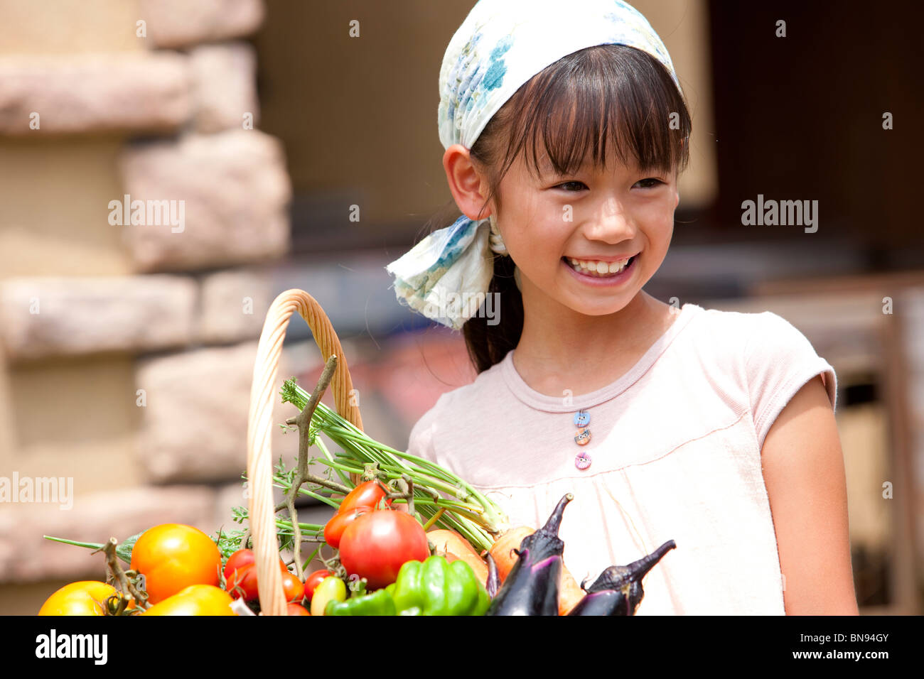 Mädchen mit Korb mit frischem Gemüse gefüllt lächelnd Stockfoto