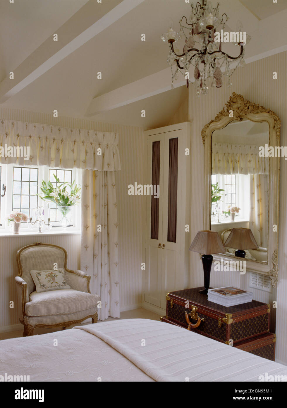 Kronleuchter und Apex Decke in Creme Land Schlafzimmer mit großen Spiegel  antiker Spiegel über der Kommode Stockfotografie - Alamy