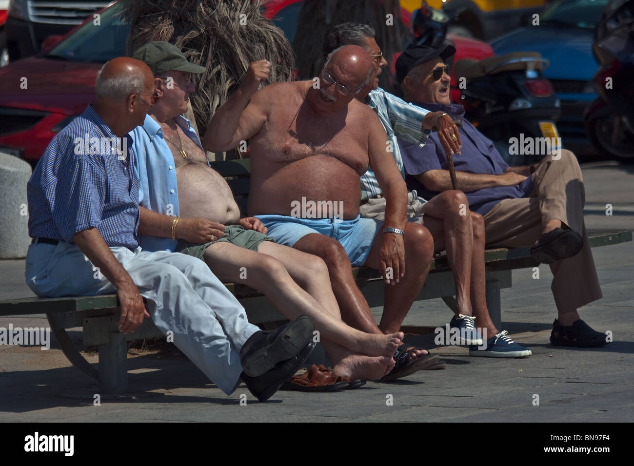 Barcelona, Spanien, Juni 2009. Fünf unbekannte Bürger sitzen auf Bank mit einem Gespräch. Stockfoto