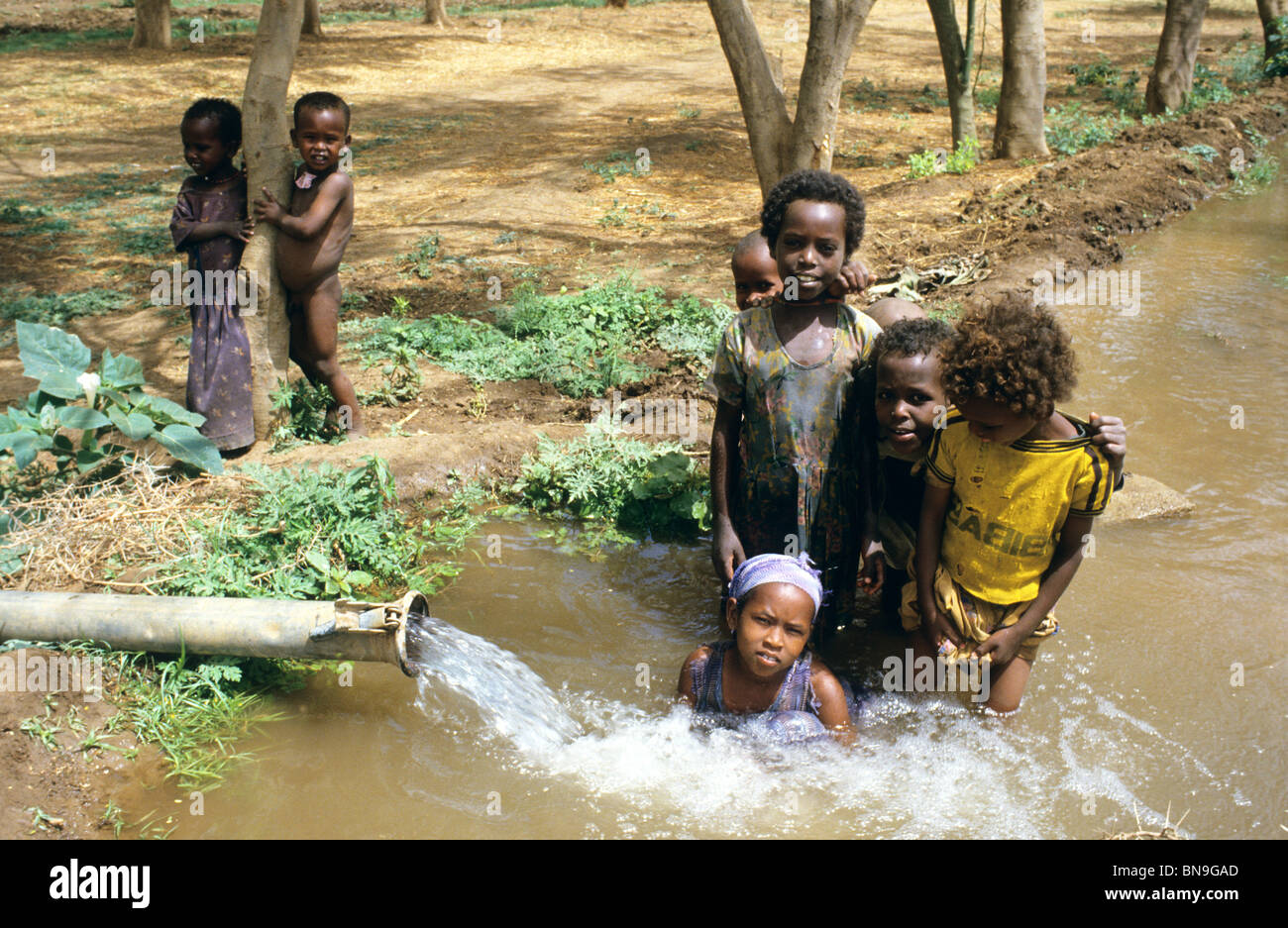 Äthiopische Clildren im Spiel durch eine Wasser-Auslauf Stockfoto