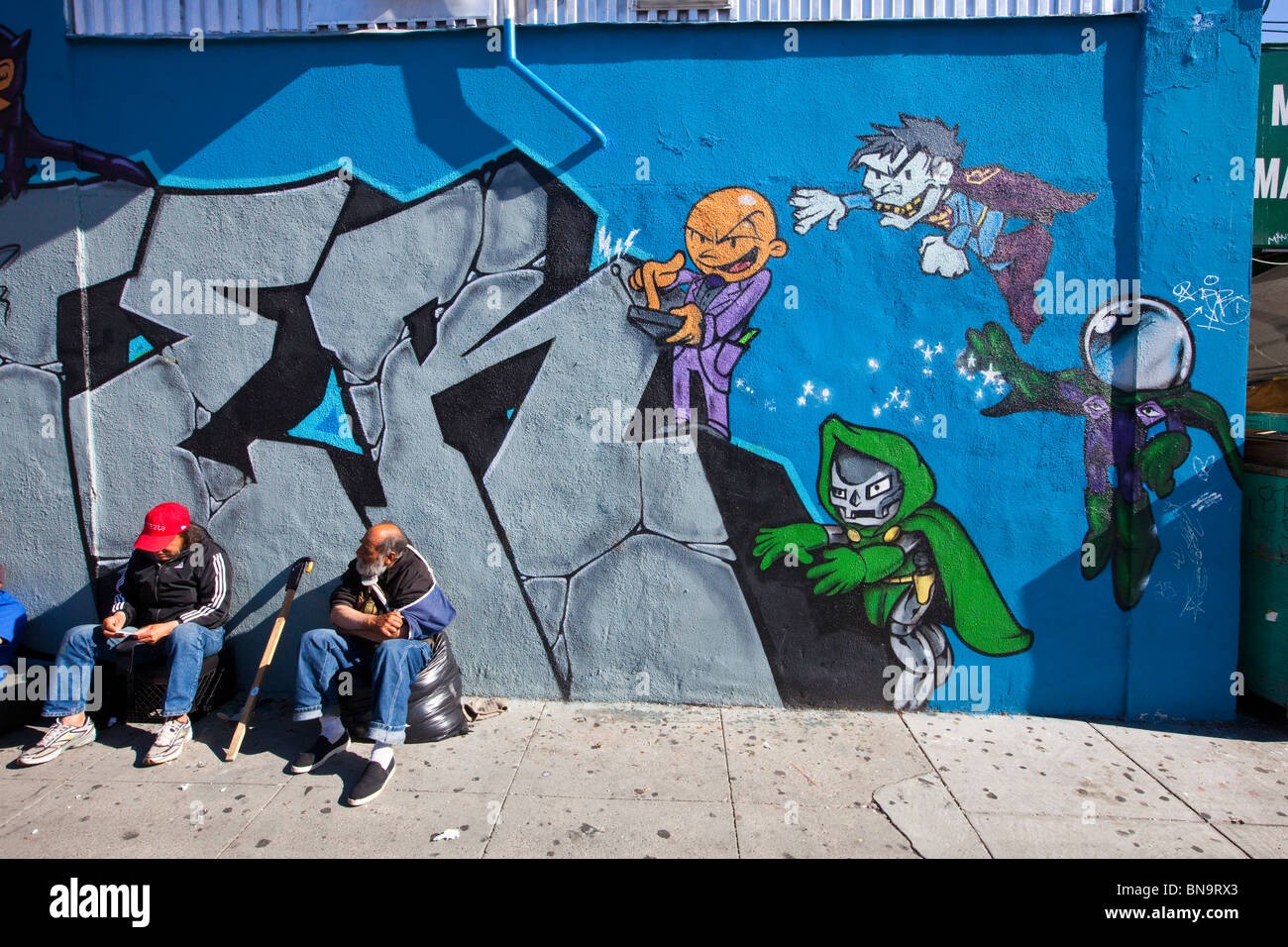 Cartoon-Graffiti und Obdachlose Männer im Mission District von San Francisco, CA Stockfoto