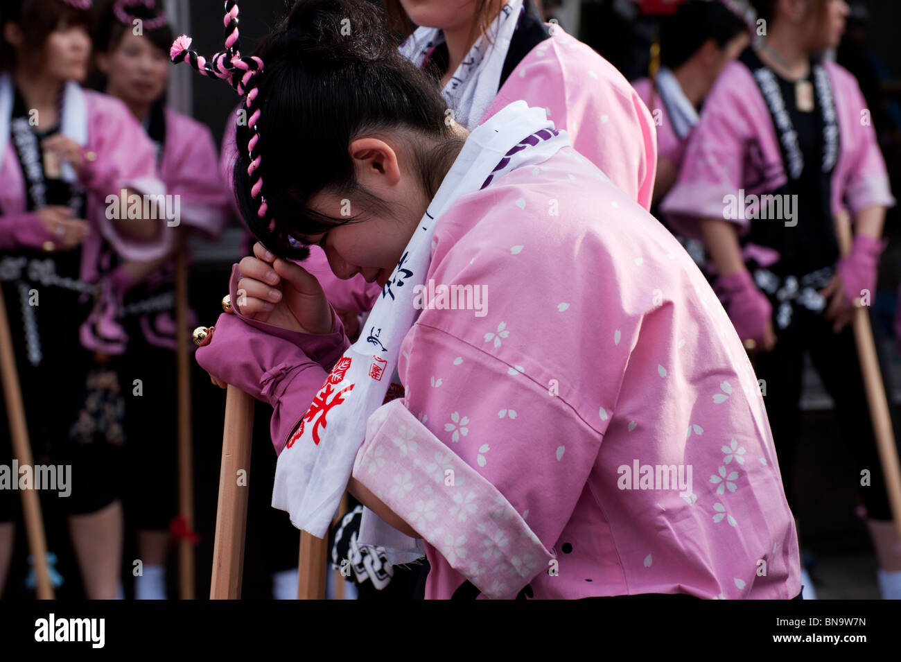 Eine Japanerin - gekleidet in einem rosa Happi Mantel - nimmt eine Pause während einer Nagamochi Tanz auf dem Onbashira-Festival. Stockfoto