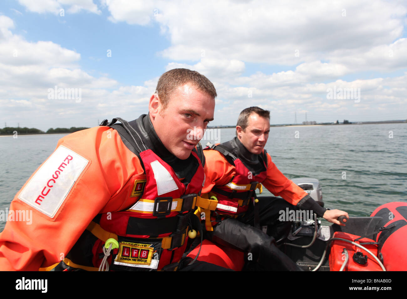 Feuerwehrmann, training, um eine Person zu retten, die im offenen Wasser ertrinken. Verwenden sie Boote und Seile zum Abrufen von der Person in der Stockfoto