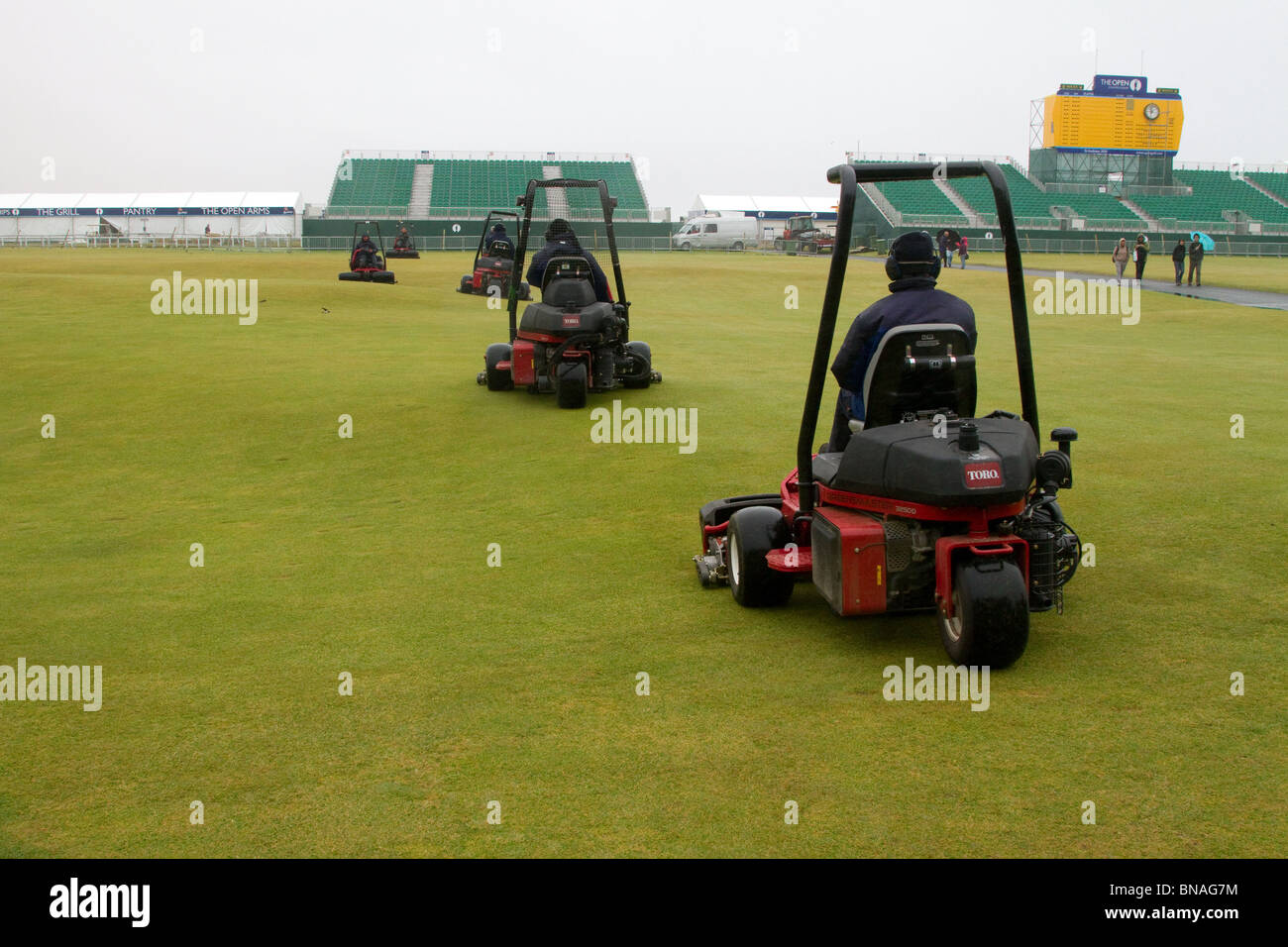 Riding Greens mäht Maschinen; Grass Cutter und Green Keepers mähen den Old Course; Teamwartung beim 139th British Open Golf 2010, 15.-18. Juli, St Andrews, Schottland, Großbritannien. Die Funktion des Mähens ist es, den Golfplatz für das Spiel vorzubereiten, obwohl Mähmuster häufig verwendet werden, um Merkmale eines Golfplatzes hervorzuheben. Das Mähmuster kann einen großen Einfluss auf das Aussehen des Golfplatzes und die Gesundheit des Rasens haben, während Sie Ihre Arbeit und den Kraftstoffverbrauch Line Items beeinflussen. Die gängigsten Methoden des Fairwaymähens sind Striping, Konturmähen, der klassische Schnitt sowie Schieben und Ziehen. Stockfoto